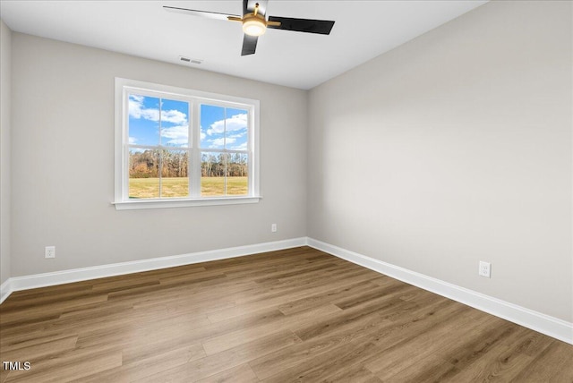 empty room with ceiling fan and light hardwood / wood-style flooring