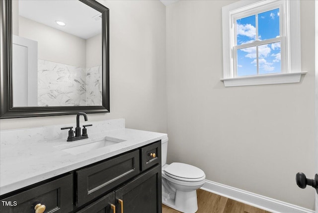 bathroom with hardwood / wood-style flooring, vanity, and toilet