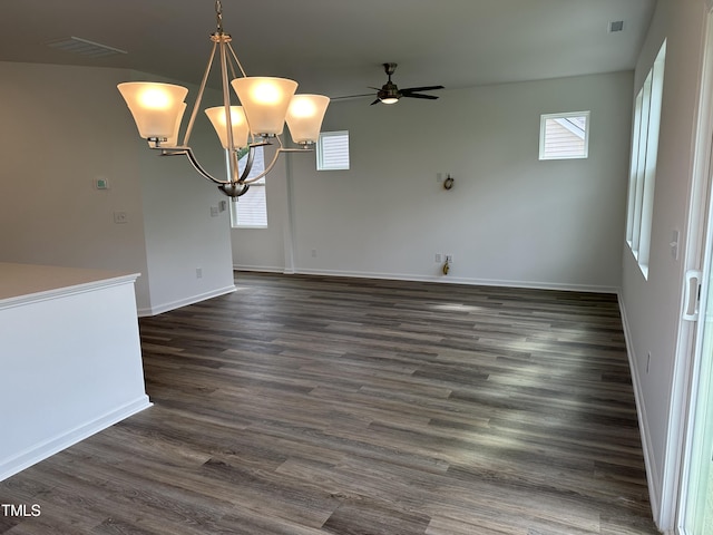 unfurnished dining area with dark wood-type flooring, a healthy amount of sunlight, and ceiling fan with notable chandelier