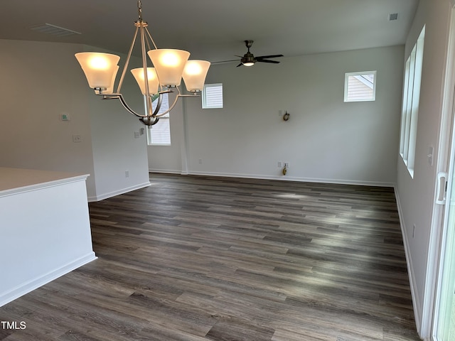 unfurnished dining area featuring baseboards, ceiling fan with notable chandelier, dark wood-type flooring, and visible vents