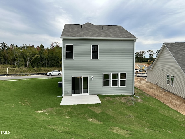 rear view of property featuring a yard and a patio area