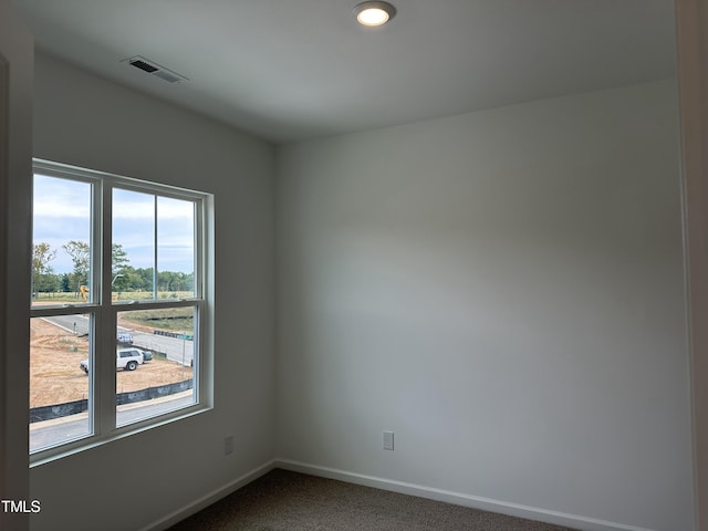 unfurnished room with recessed lighting, baseboards, dark colored carpet, and visible vents