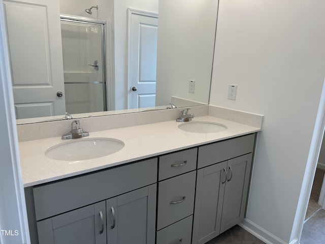 bathroom featuring a sink, tile patterned flooring, a stall shower, and double vanity