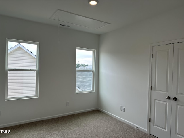 carpeted spare room with recessed lighting, baseboards, visible vents, and attic access