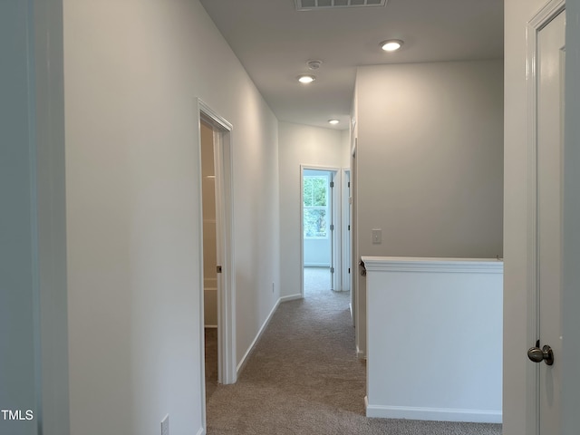 corridor featuring carpet floors, baseboards, recessed lighting, and visible vents