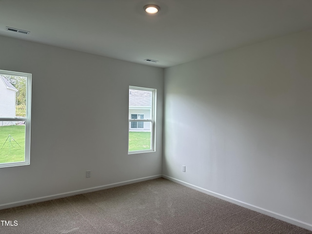 empty room with baseboards, visible vents, and plenty of natural light