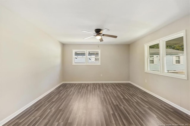 spare room with ceiling fan, dark hardwood / wood-style floors, and a healthy amount of sunlight