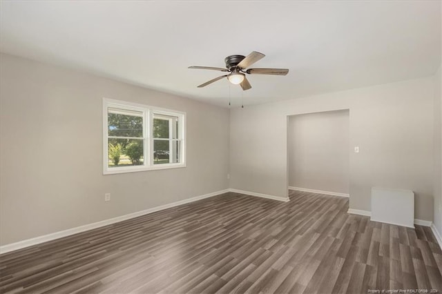 unfurnished room with ceiling fan and dark hardwood / wood-style flooring