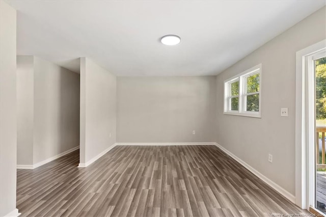 unfurnished room with dark wood-type flooring