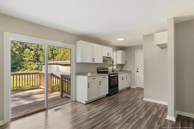 kitchen with white cabinets, light stone countertops, dark wood-type flooring, and electric range