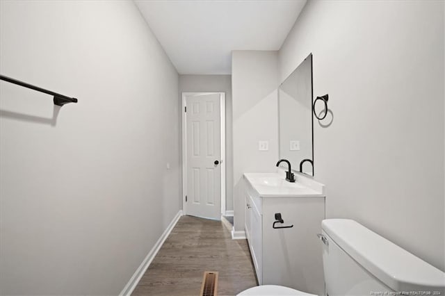 bathroom featuring hardwood / wood-style flooring, vanity, and toilet