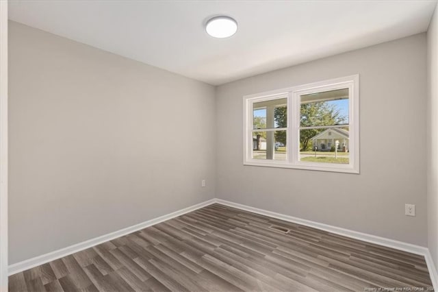 spare room with dark wood-type flooring