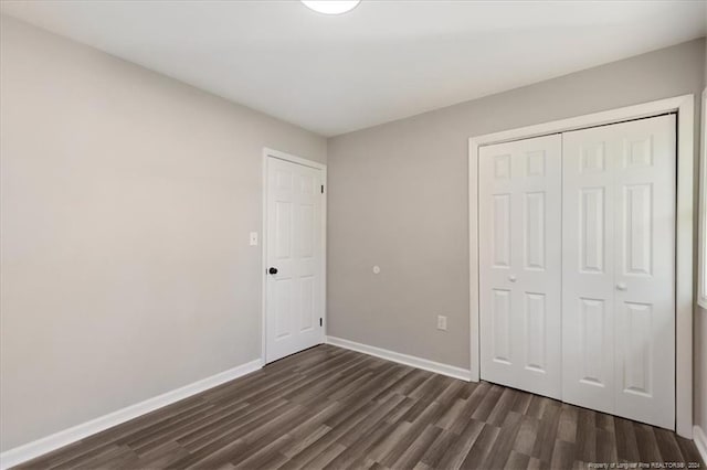 unfurnished bedroom featuring a closet and dark hardwood / wood-style floors