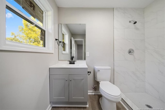 bathroom with plenty of natural light, wood-type flooring, vanity, and toilet