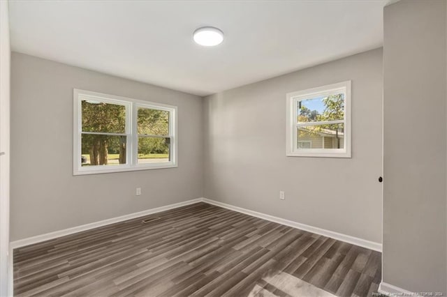 empty room featuring dark hardwood / wood-style floors and a healthy amount of sunlight