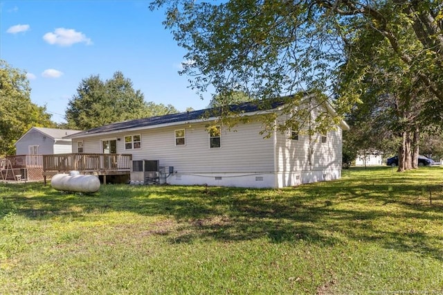 rear view of property featuring a yard and a wooden deck