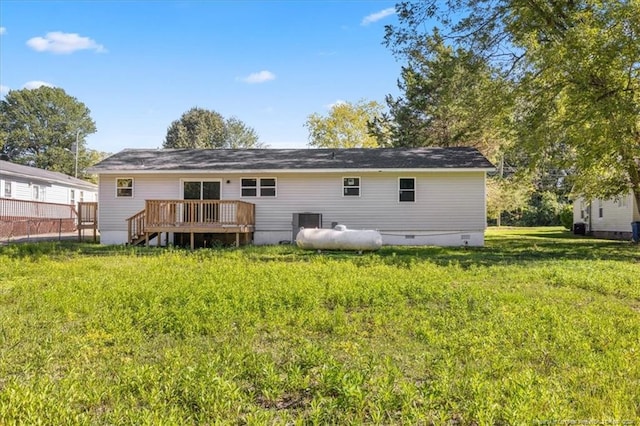 back of property with a yard and a wooden deck