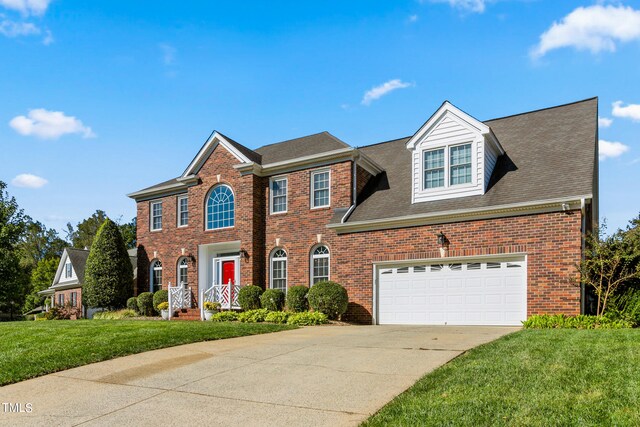 colonial inspired home with a garage and a front lawn