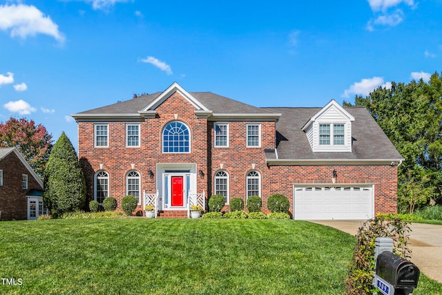 colonial home with a front yard and a garage