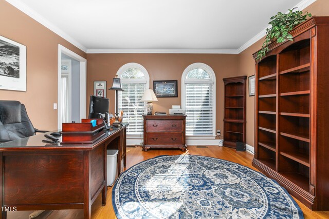 office area with light hardwood / wood-style flooring and crown molding