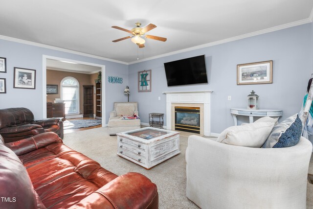 living room with crown molding, light carpet, a fireplace, and ceiling fan