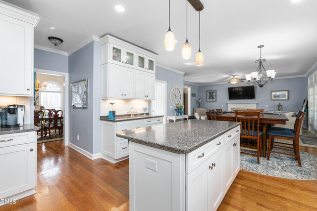 kitchen with light hardwood / wood-style floors, white cabinets, and pendant lighting