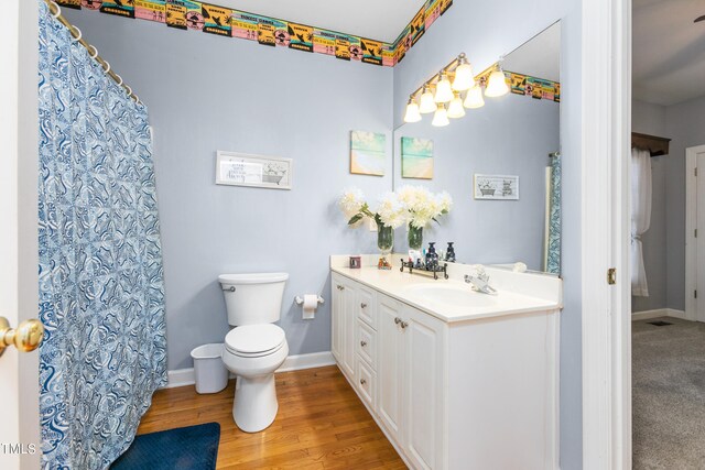 bathroom with vanity, toilet, and wood-type flooring