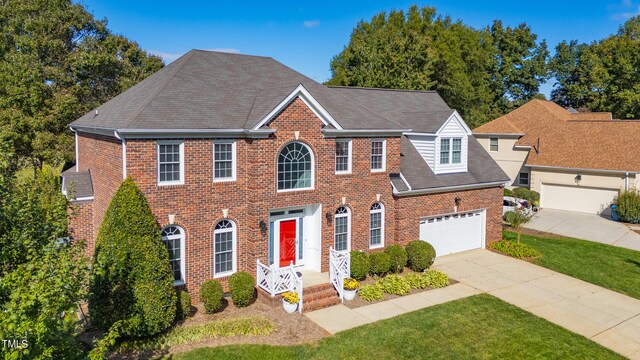 colonial-style house with a front yard and a garage