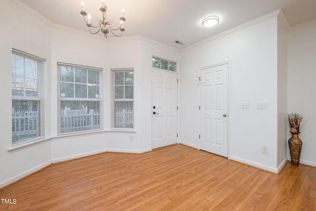 entryway with a chandelier, light hardwood / wood-style flooring, a healthy amount of sunlight, and ornamental molding