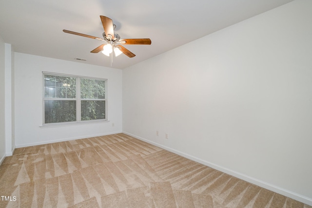 spare room featuring ceiling fan and light carpet