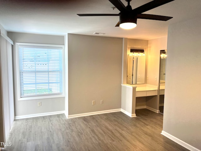 unfurnished bedroom with wood-type flooring, ceiling fan, and built in desk