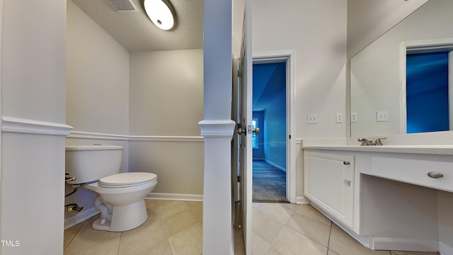 bathroom with vanity, tile patterned flooring, toilet, and a textured ceiling