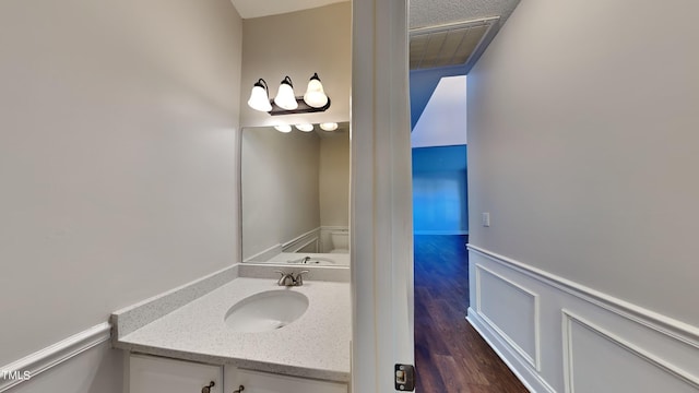 bathroom with vanity, toilet, and hardwood / wood-style flooring