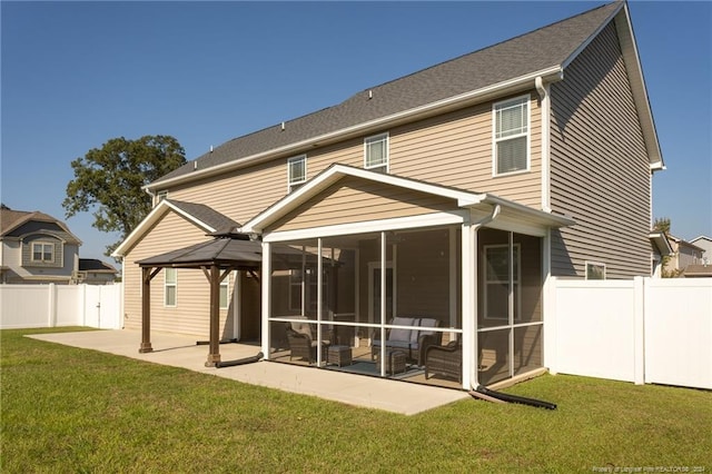 rear view of house featuring a gazebo, a sunroom, a lawn, and a patio area