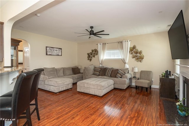 living room with dark hardwood / wood-style flooring and ceiling fan