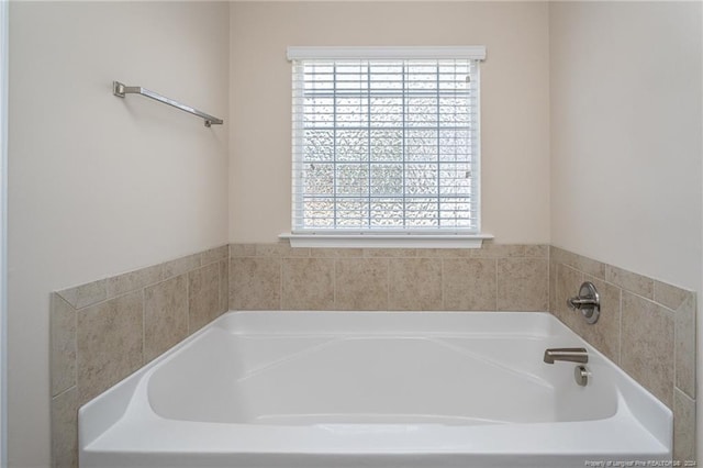 bathroom featuring a tub to relax in and a healthy amount of sunlight