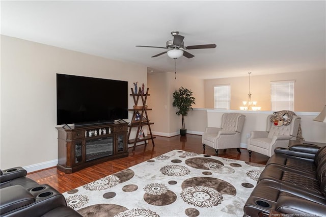 living room with ceiling fan with notable chandelier and dark hardwood / wood-style floors