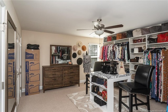 walk in closet with ceiling fan and light colored carpet