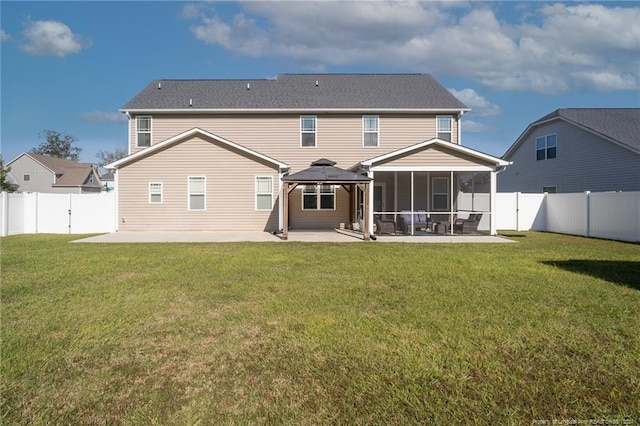 rear view of property featuring a gazebo, a yard, a sunroom, and a patio area