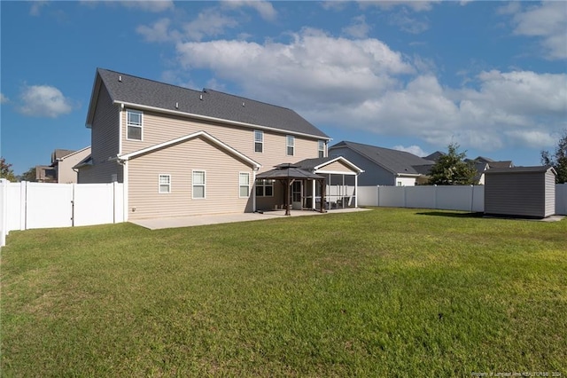 back of house featuring a patio, a storage shed, and a lawn