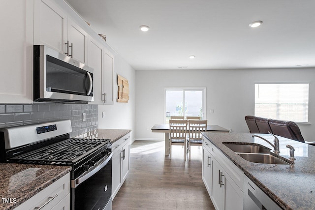 kitchen with sink, appliances with stainless steel finishes, white cabinetry, and plenty of natural light