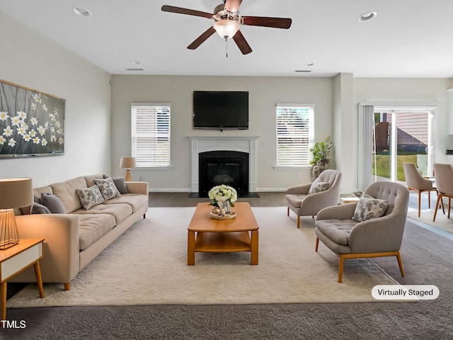 carpeted living room with ceiling fan