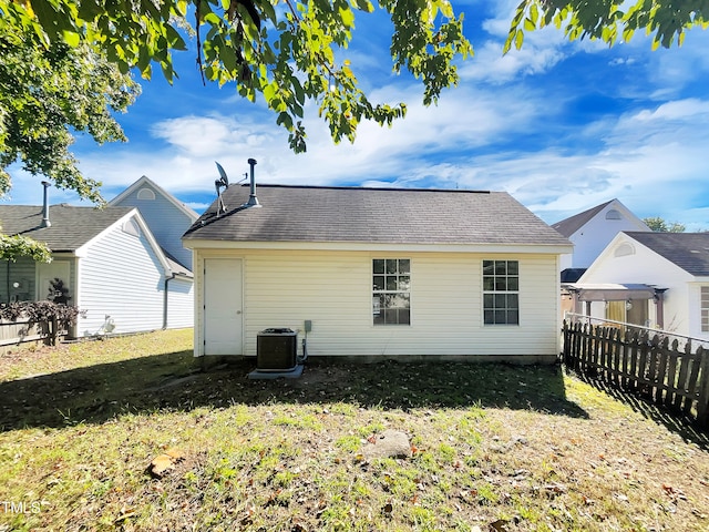 back of house featuring a yard and central air condition unit