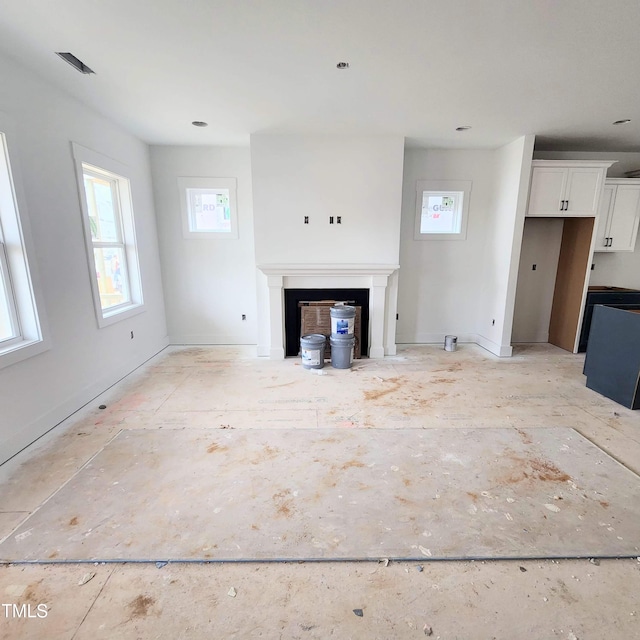 unfurnished living room with a healthy amount of sunlight and a fireplace