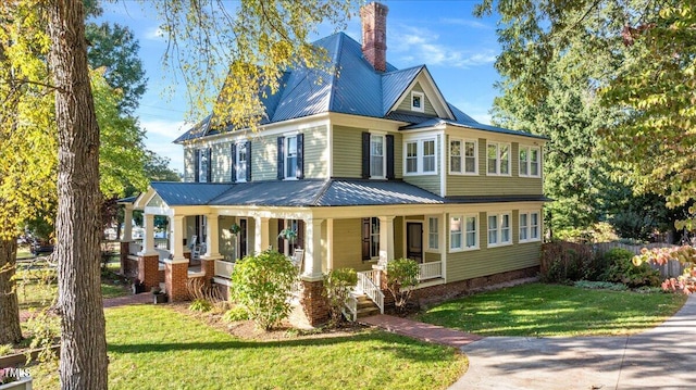 view of front of house with a front yard and covered porch