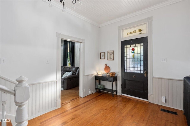 entrance foyer with crown molding and hardwood / wood-style floors