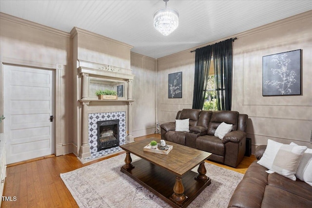 living room with a fireplace, an inviting chandelier, and light hardwood / wood-style flooring