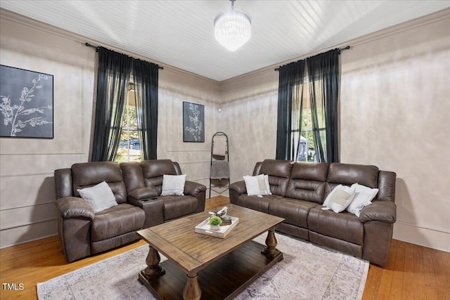 living room with wood-type flooring and ornamental molding