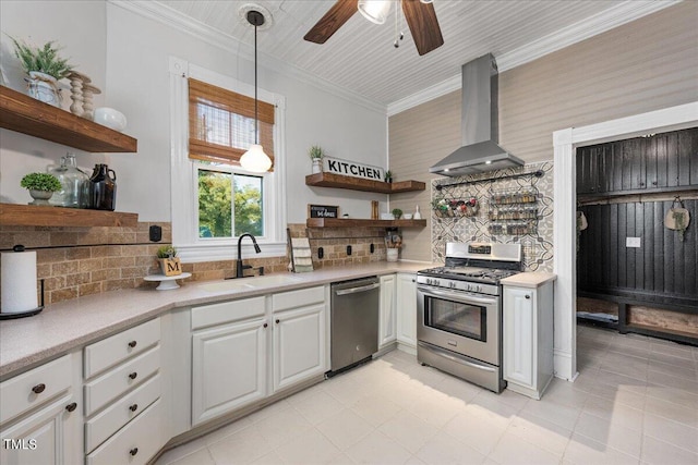 kitchen with decorative backsplash, stainless steel appliances, sink, wall chimney range hood, and white cabinetry