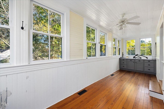 unfurnished sunroom featuring ceiling fan